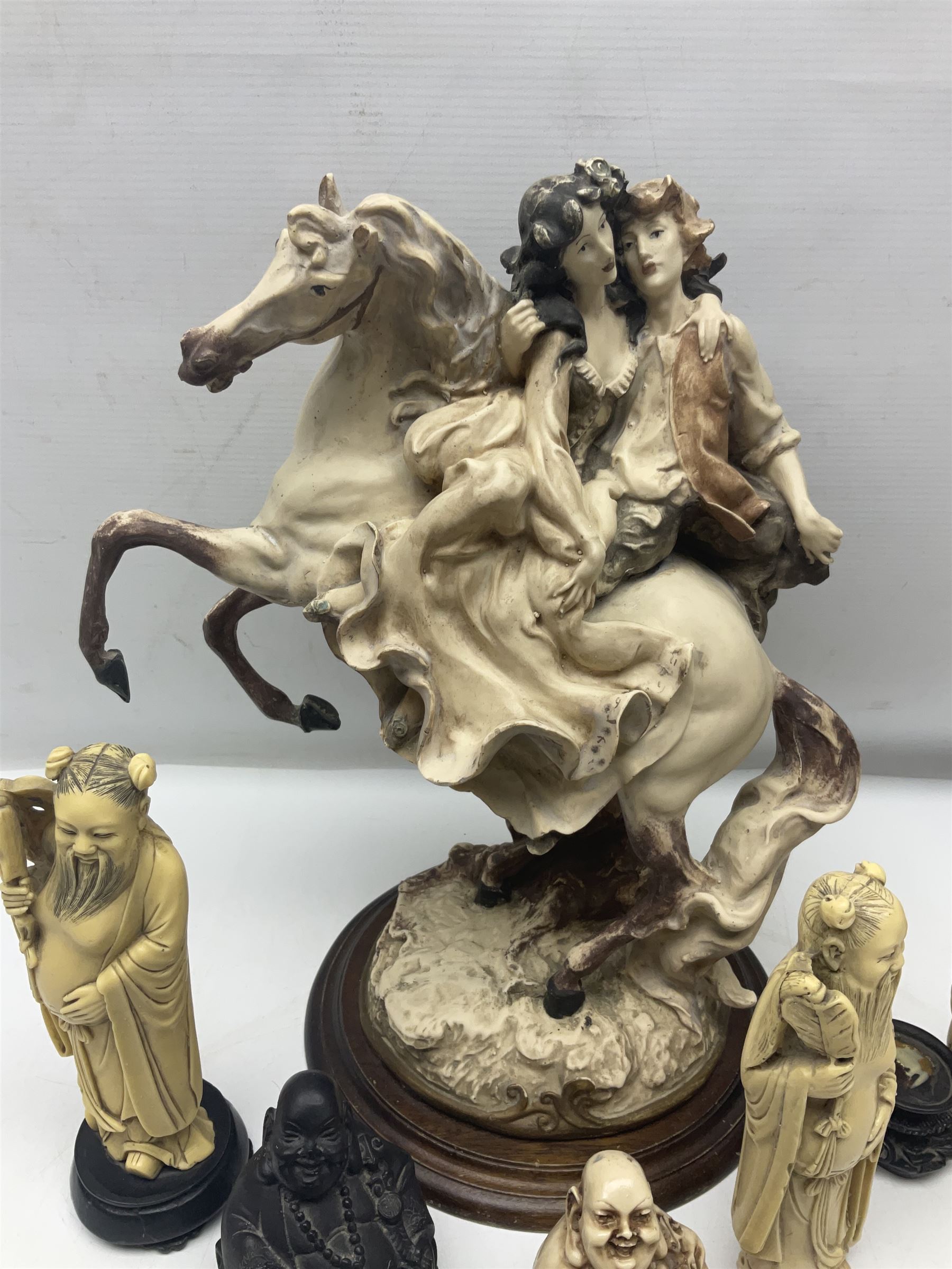 Composite figure of a couple upon a rearing horse, together with a collection of resin immortals and two bone chests 