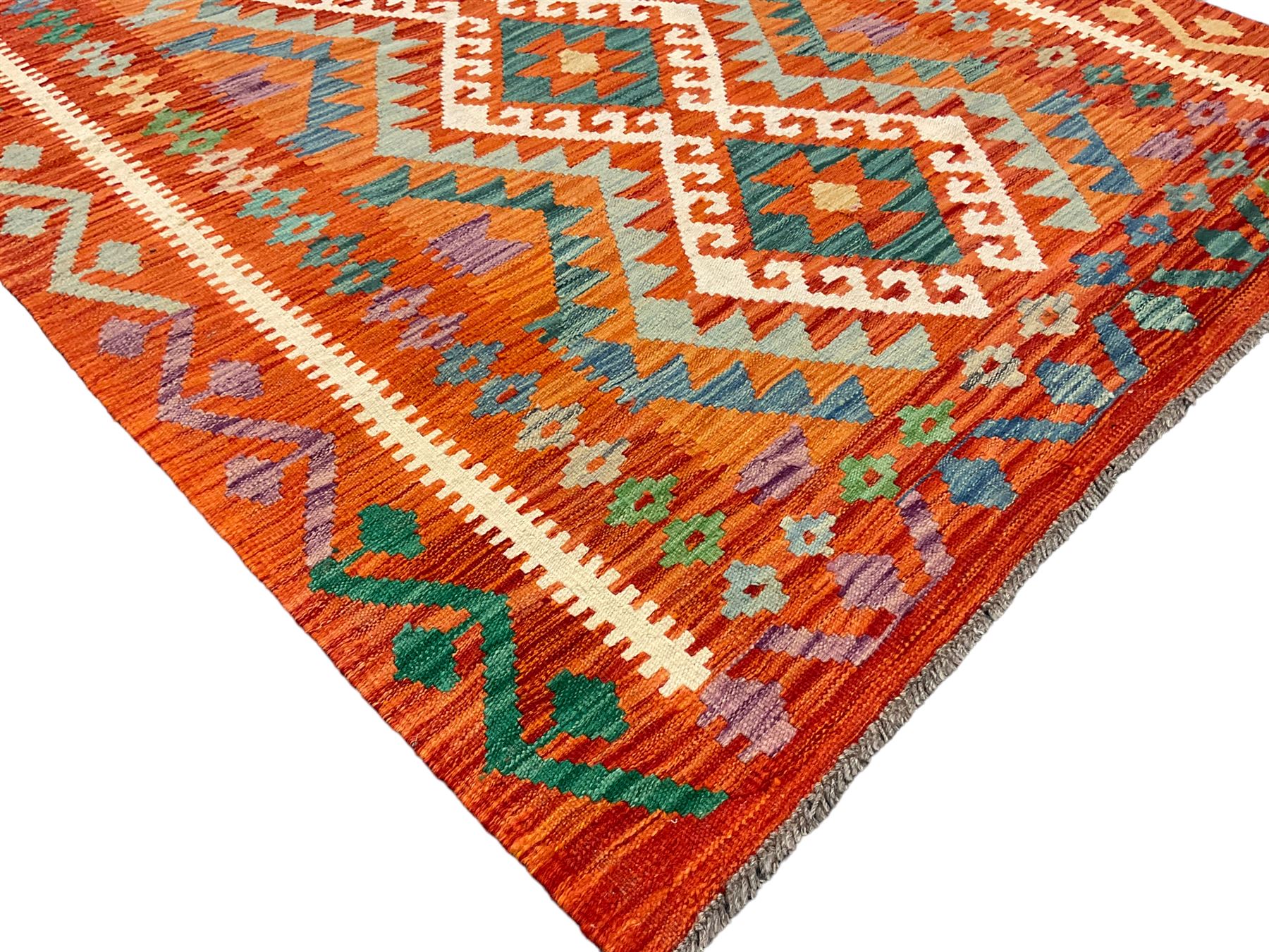 Anatolian Turkish Kilim amber ground rug, the field decorated with four lozenges with ivory outline, the double banded orange border with repeating geometric patterns 