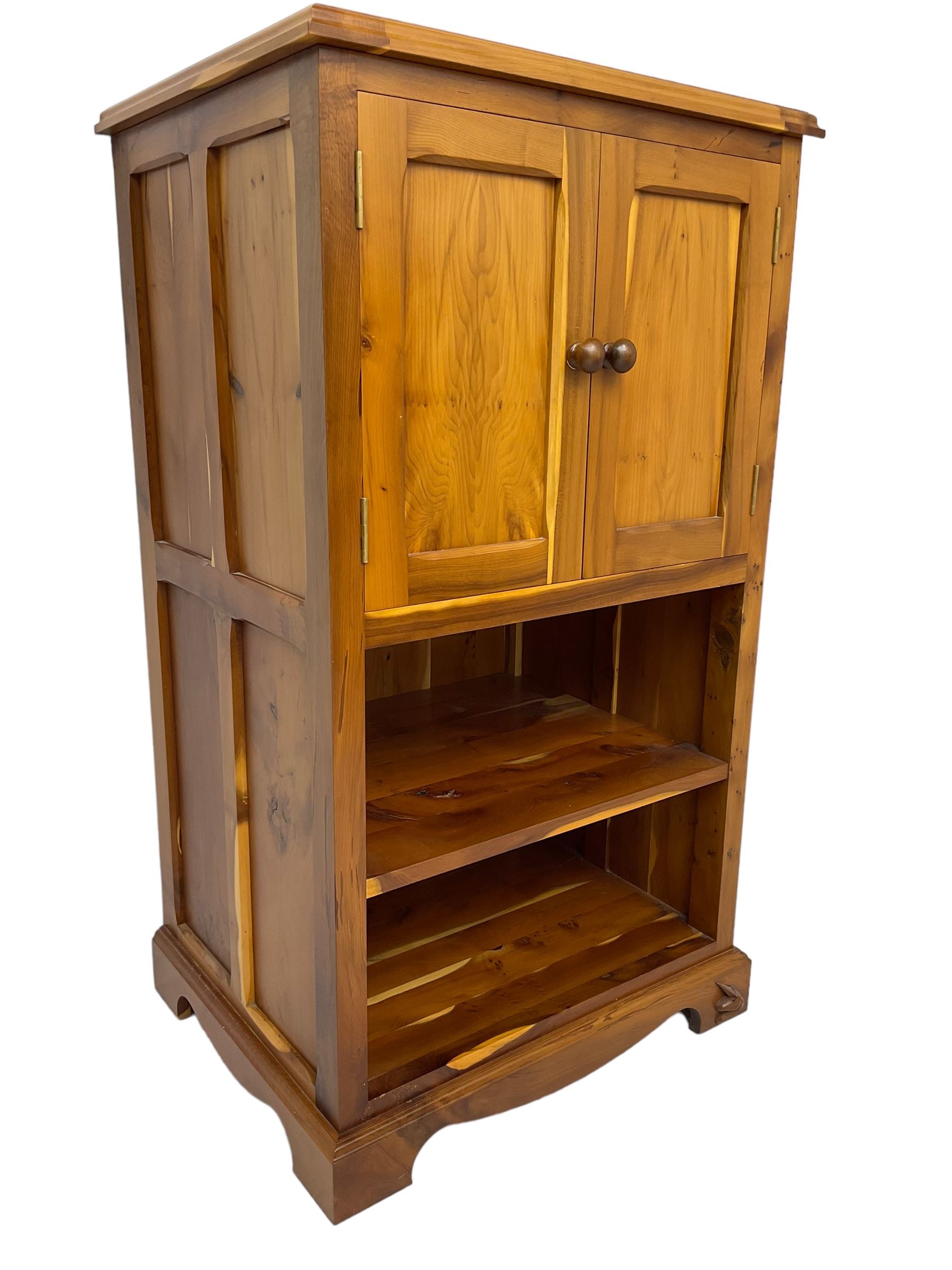 Unicornman - yew wood cabinet, moulded hinged lid over two panelled doors and shelves (W56cm, H99cm, D45cm); and four Unicorn man CD racks two in yew wood and two in oak (W20cm, H36cm, D20cm); all carved with unicorn signature and by Geoff Gell, Coxwold
