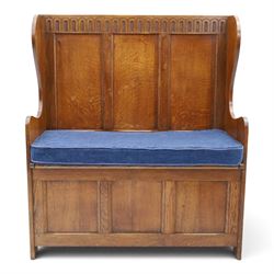 Early 20th century oak box settle, panelled back with arcaded carved rail, swept sides and...