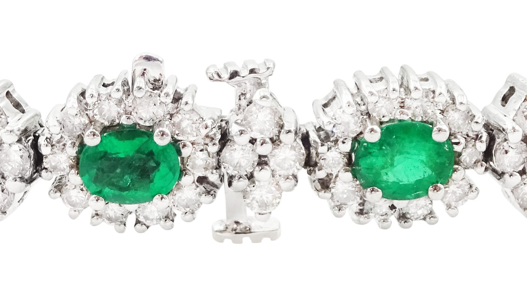 18ct white gold emerald and diamond bracelet, fifteen oval cut emeralds, each surrounded by ten round brilliant cut diamonds and spaced by a further four diamonds, stamped, total emerald weight approx 3.30 carat, total diamond weight approx 2.10 carat