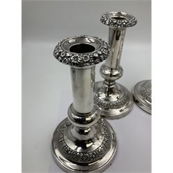 Four George III silver candlesticks, each upon knopped stem and weighted circular stepped foot, the foot and removable sconce repousse decorated with a band of flower heads, hallmarked to sconce and foot Thomas & John Settle, Sheffield 1820, H17.5cm