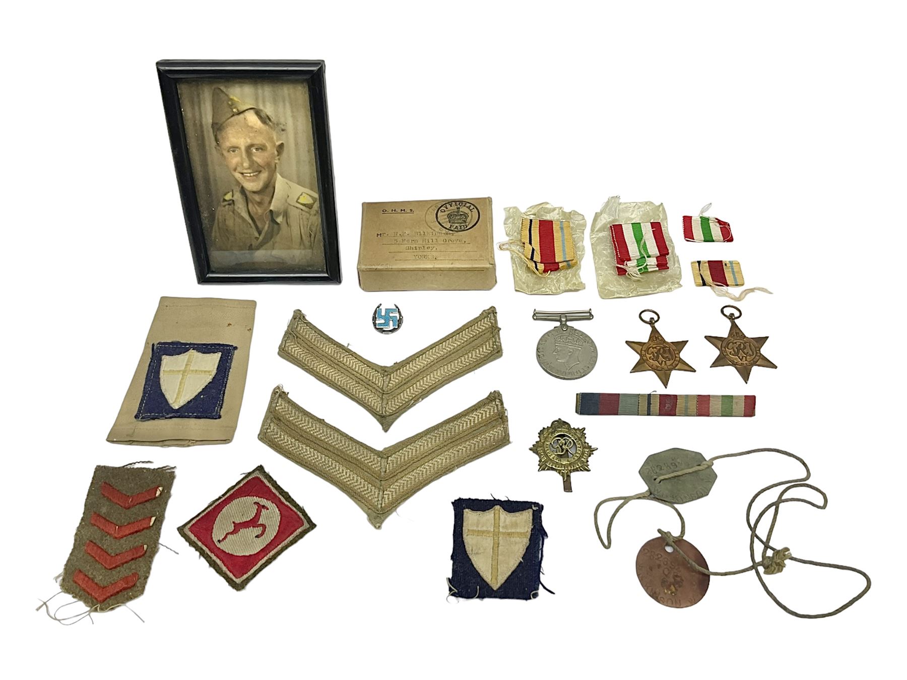 WWII group of three medals comprising 1939-45 War Medal and Italy and Africa Stars in issue box; dog tags for 282894 W. Wilkinson with framed photograph in uniform; and small quantity of cloth and metal badges including RAOC cap badge