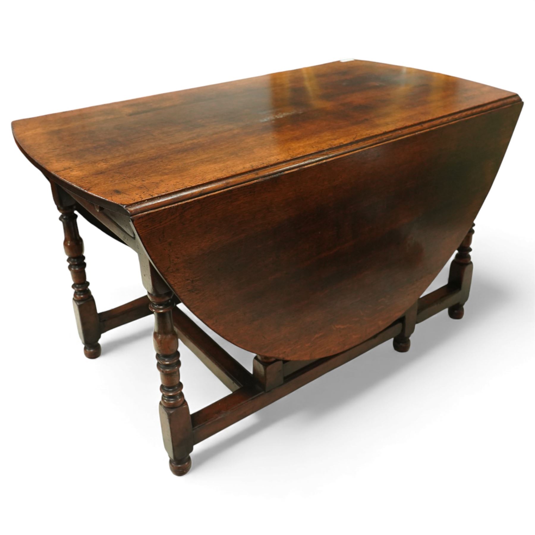 Large 18th century design oak drop-leaf dining table, oval top with twin hinged drop leaves, drawers to either end, raised on turned supports united by an H-stretcher base