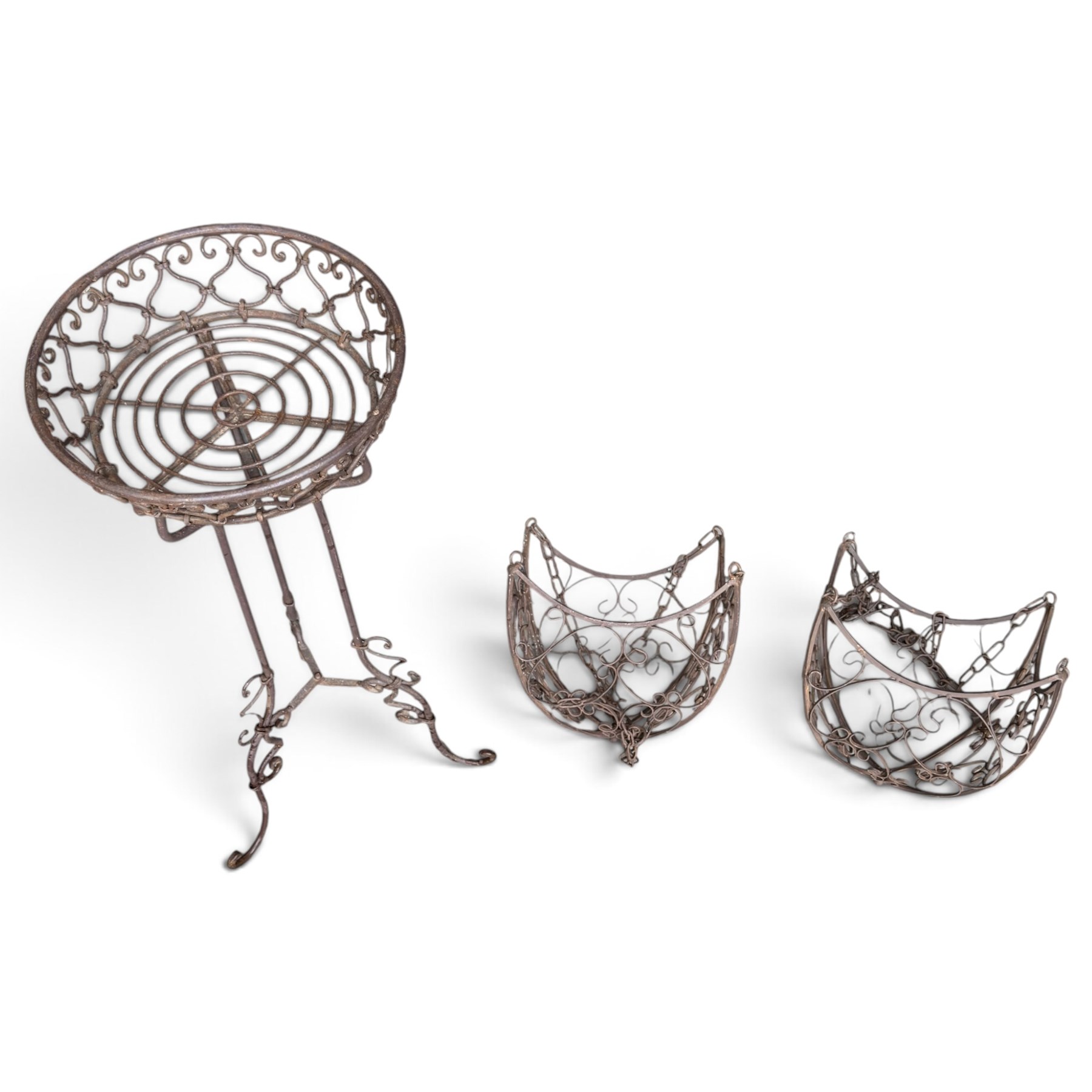 Three wrought iron garden basket planters, comprising a circular pierced and scrolling basket on tall tripod stand with scrolling supports (W31cm H76cm), and a pair of matching hanging baskets (W37cm H30cm)