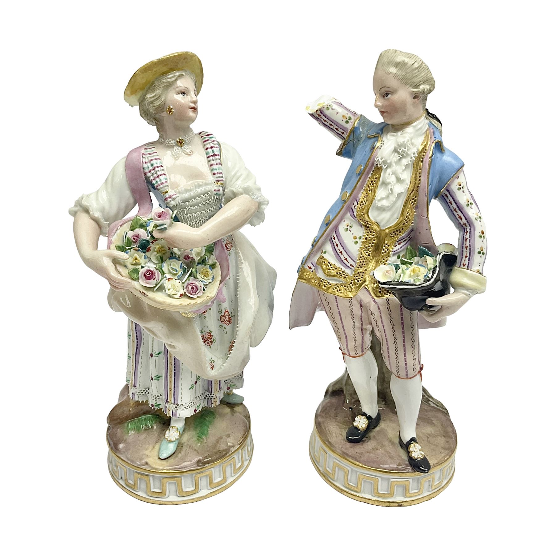 Pair of late 19th/early 20th Century Meissen figures, modelled as flower sellers, after the original by Michel Victor Acier, she holding basket of flowers, he holding flowers in his hat, each with underglaze cross swords mark beneath, tallest H16.5cm