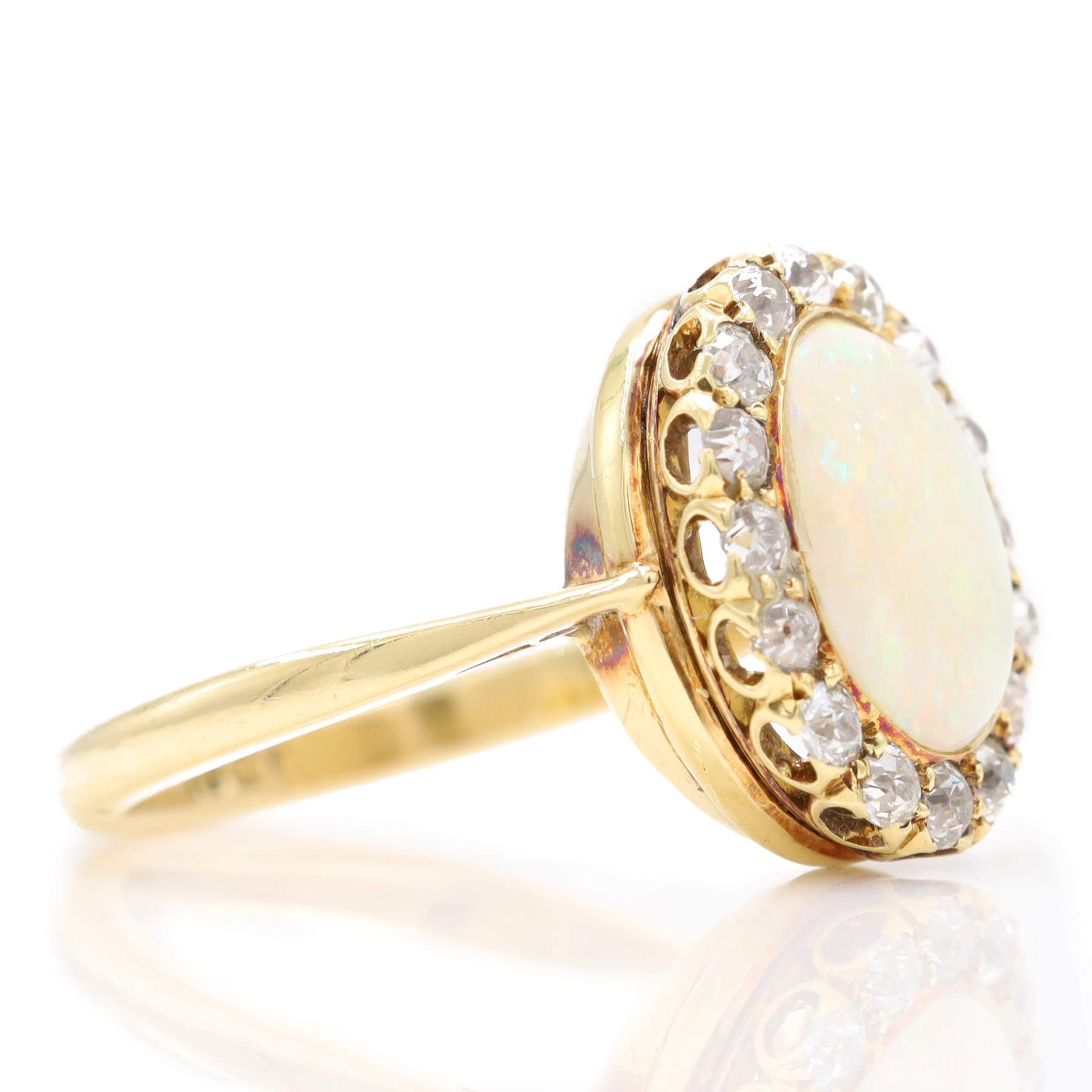 Early 20th century gold opal and diamond cluster ring, single oval cabochon opal, surrounded by sixteen old cut diamonds, stamped 18ct, total diamond weight approx 0.65 carat