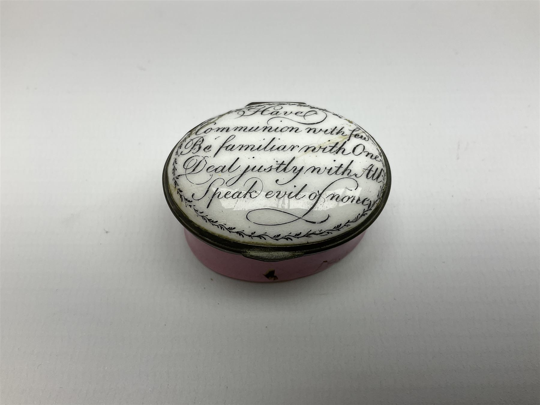 Late 18th century Staffordshire enamel patch box, of oval form with pink base, the hinged cover inscribed 'Have Communion with few, Be familiar with One, Deal justly with All, Speak evil of none' upon a white ground, opening to reveal mirror beneath, W4cm