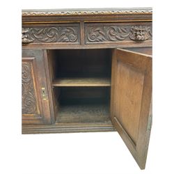 Victorian heavily carved oak sideboard, the moulded top carved with foliate decoration to the edge, fitted with two drawers and three cupboards, the drawer fronts carved with green man mask handles and scrolling foliage, the panelled doors carved with interlacing foliage, on turned compressed bun feet
