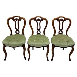 Set of six carved Victorian walnut balloon back dining chairs, button upholstered in green velvet fabric, back with foliate carved decoration supported on scroll form legs 