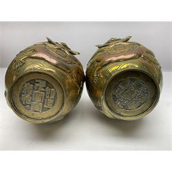 Pair of Chinese brass vases, of ovoid form with elongated neck and fluted rim, decorated in high relief with a dragon chasing a flaming pearl around the neck, the body with dragons, birds and buildings, with character marks beneath, H25cm