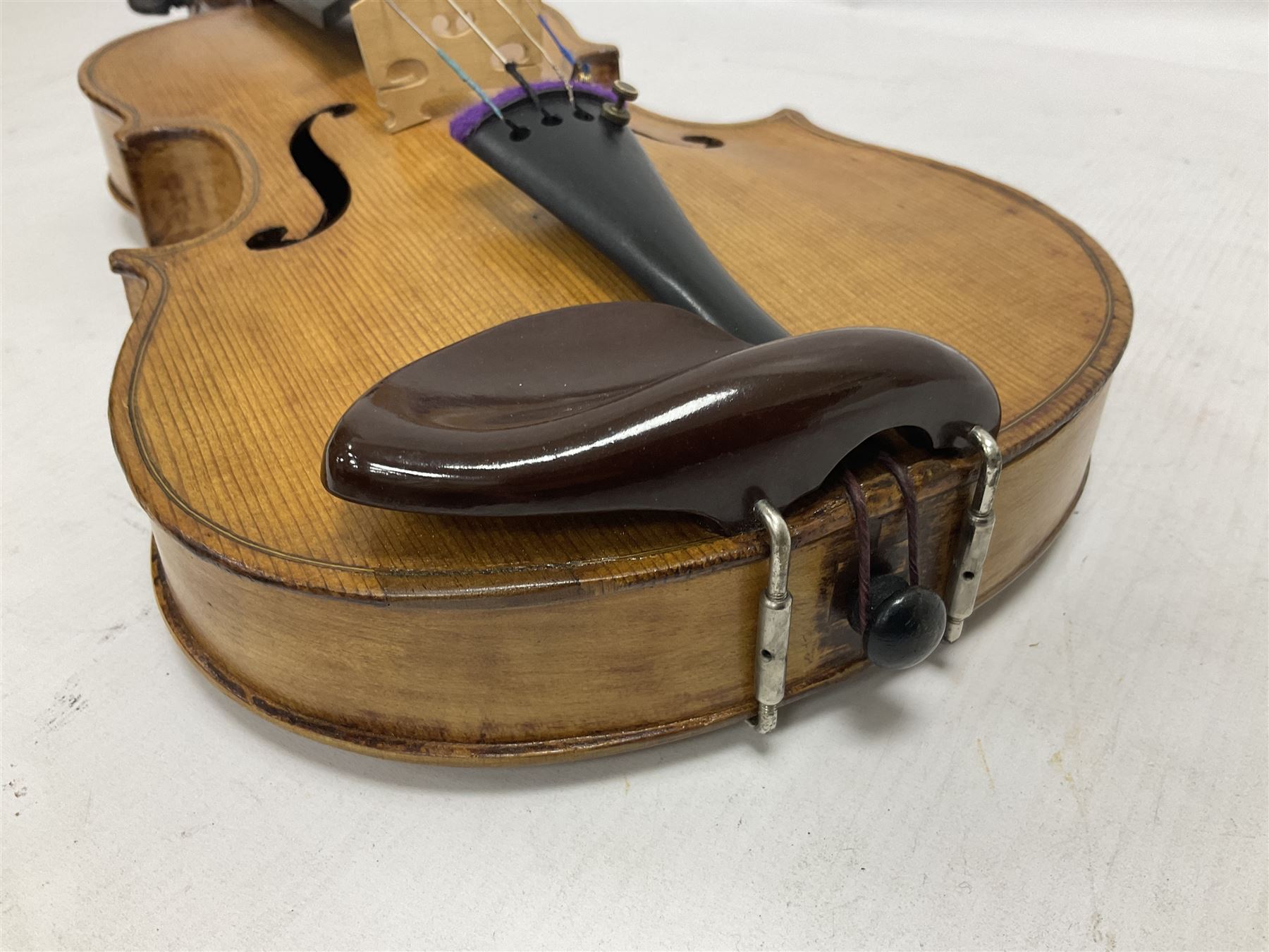 Copy of a full size Stradivarius violin, with an ebonised fretboard, tailpiece and tuning pegs, with a polished chin rest  Length 60cm