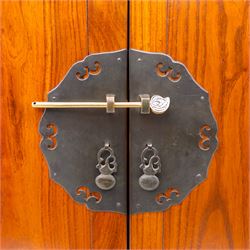 20th century Thai elm compound cabinet, formed of three stacking chests each enclosed by double panelled doors with decorative wrought metal lock plates and hinges, raised on pierced apron on stile feet