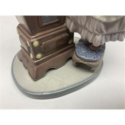 Lladro figure, Bedtime, modelled as a young girl reaching for her pet cat upon grandfather clock, sculpted by Vincente Martinez, with original box, no 5347, year issued 1986, year retired 1998, H28cm