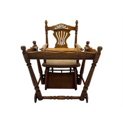 Late 19th century American oak child's metamorphic high chair and play table, carved spindle backrest with pierced splat, detachable tray with abacus and hand painted pastoral decoration, on turned supports with metal wheels