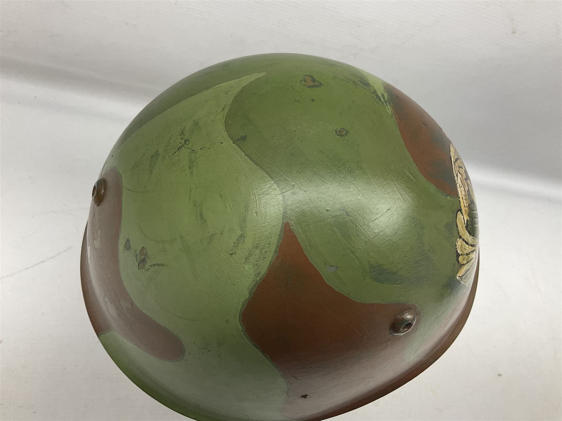 1960s Italian parachutist helmet with liner; camouflage paintwork with parachutist crest to the front