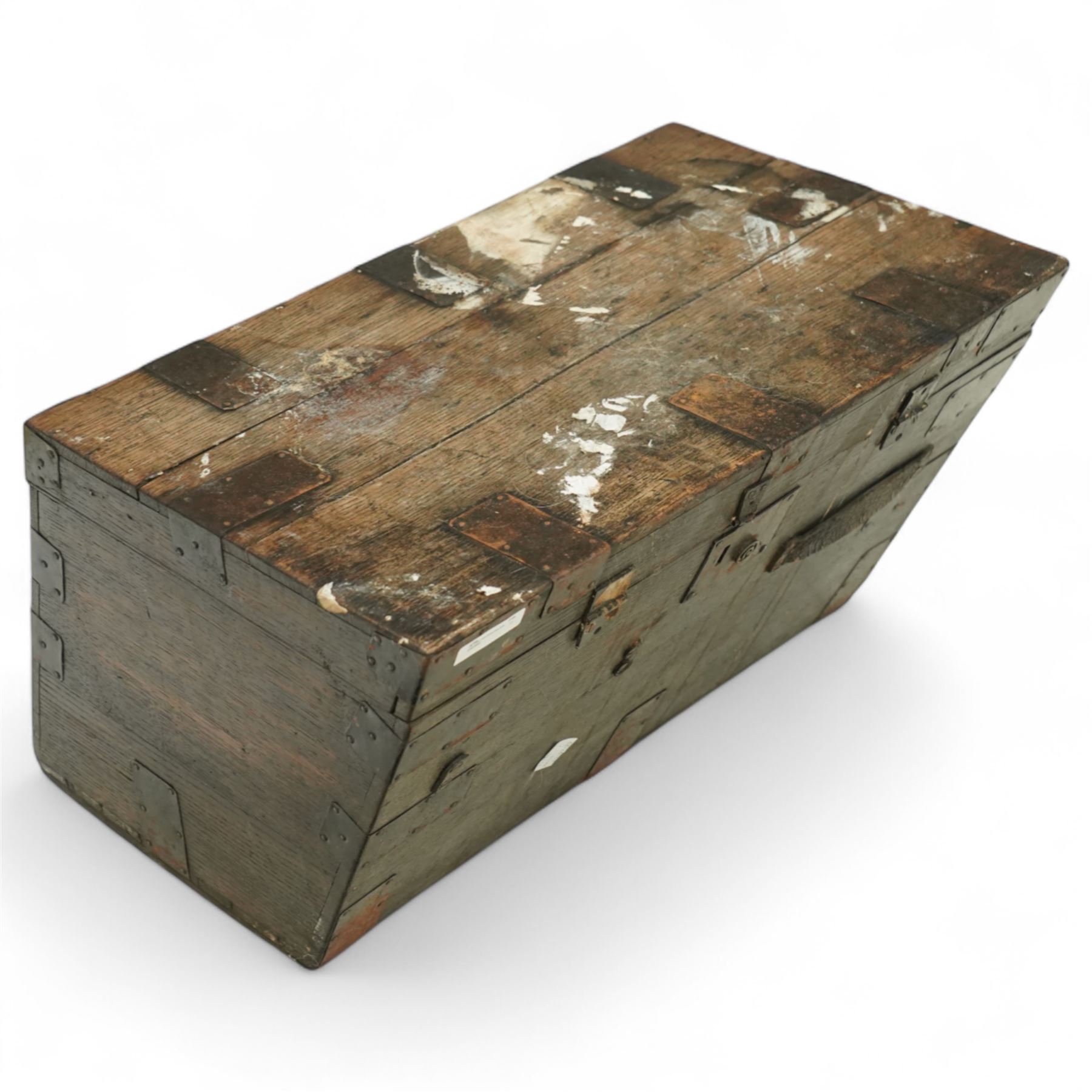 19th century metal bound ship’s trunk, of trapezoidal form with hinged lid, iron strapwork and corner reinforcements, remains of paper lining to interior