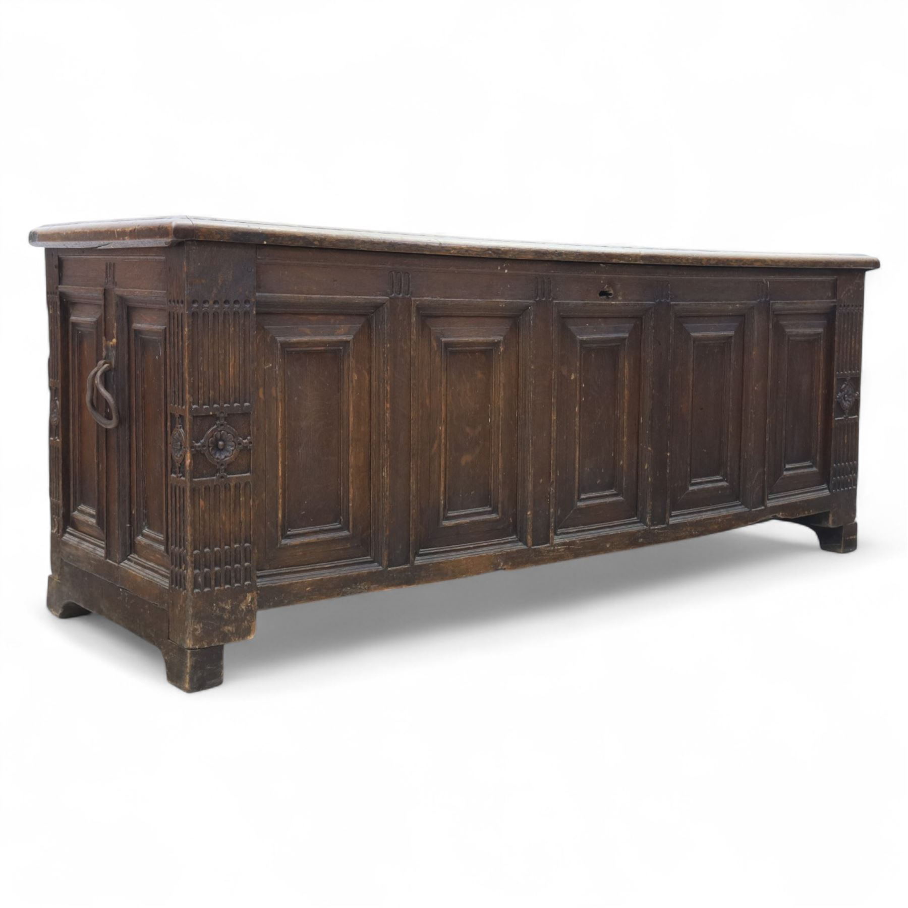18th century oak five panel chest, with planked top with chamfered edges, hinged top enclosing two candle boxes, five fielded panels flanked by foliate carvings, raised on stile supports