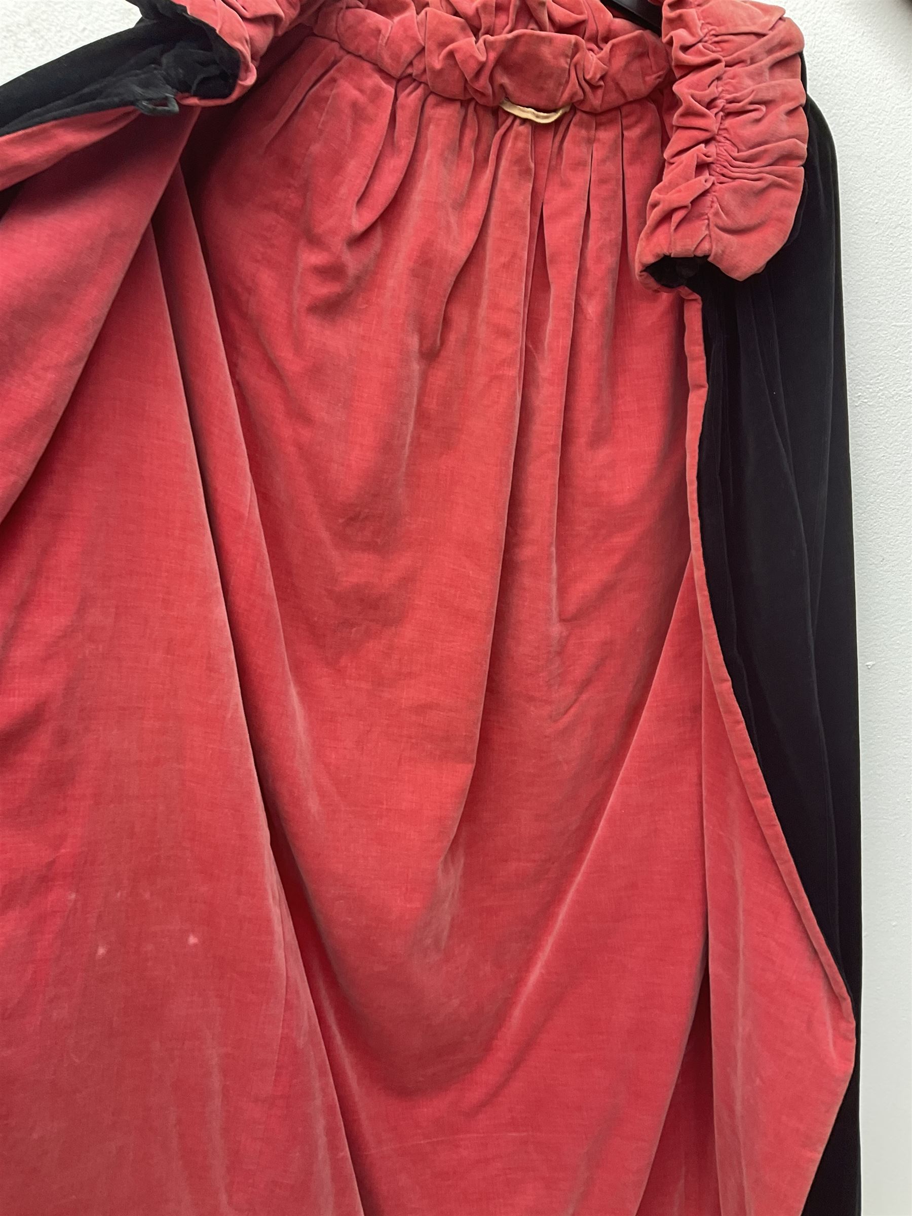 Full length 1930's childs black velvet cape, with ruched collar and red velvet lining, with a single button neck fastening 