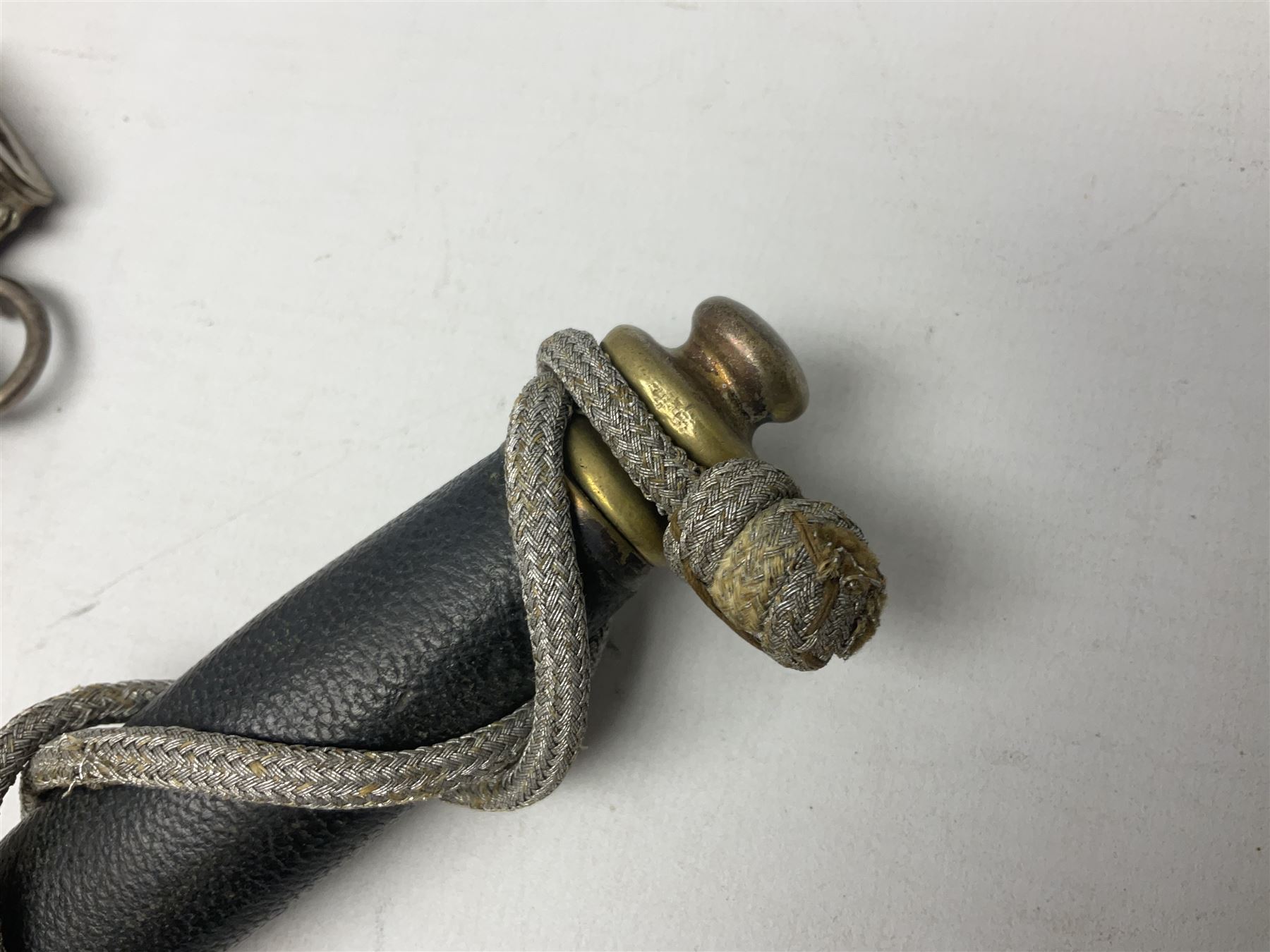 German Paul Weyersberg & Co Solingen DLV flyers dagger with 18cm steel blade, plated brass/tombac downswept cross-piece and pommel and leather covered grip, in leather and plated brass/tombac scabbard with leather hanger strap and silvered knot L35cm overall. Auctioneer's Note: After WWI Germany was forbidden an air force by the Treaty of Versailles however the Deutscher Luftsport-Verband (German Air-sport Association) was formed in March 1933 from various sports flying clubs and had branches for aeroplane, gliding and balloon flying. Under cover of the sporting DLV, many future Luftwaffe pilots trained to fly. DLV was embodied with the NSKK in March 1935 and on 1st March 1937 Luftwaffe was formed.