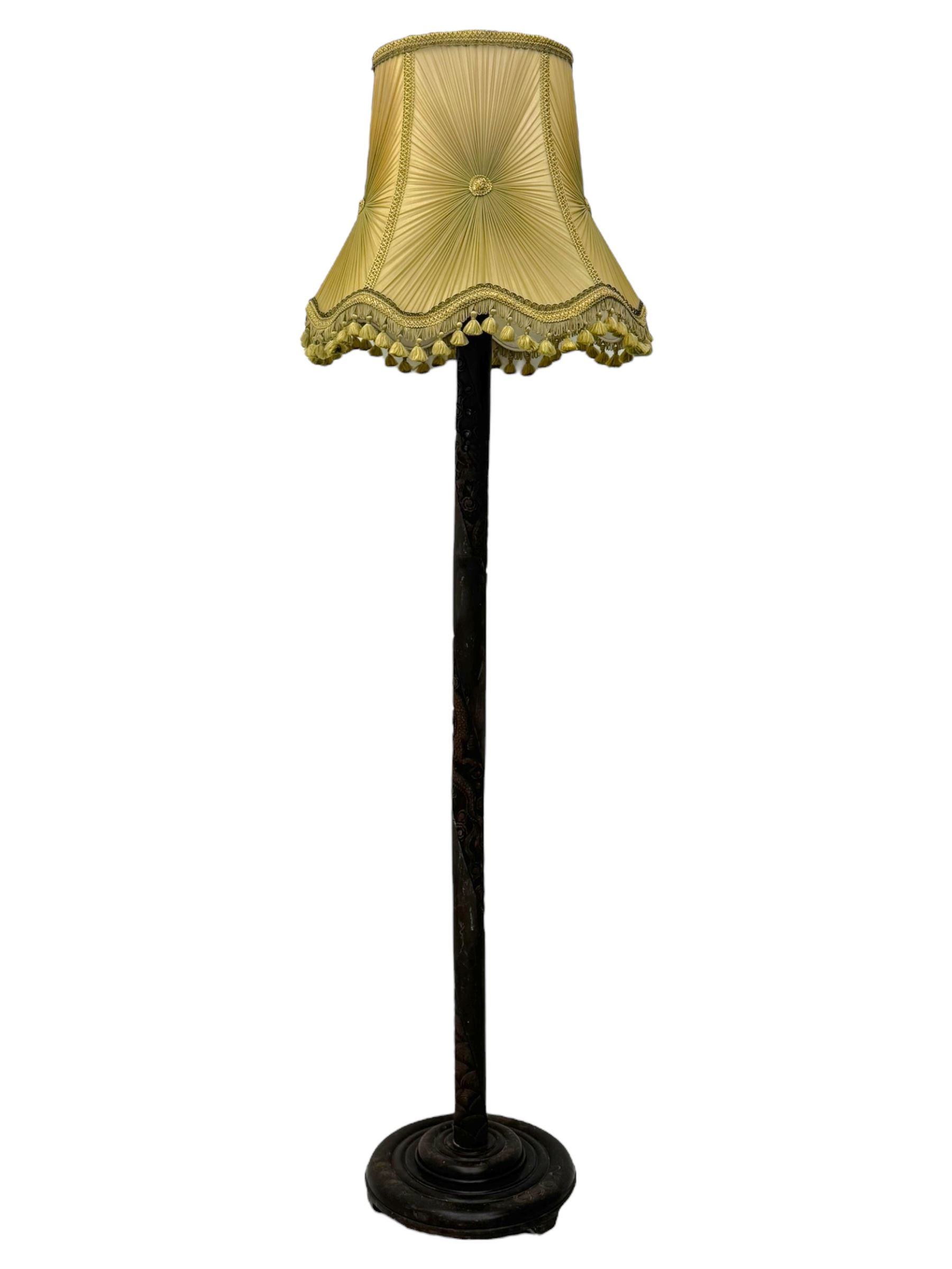 Early 20th century floor lamp, with fringed and pleated silk shade over a carved and turned column, on a circular stepped base