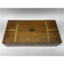 Naval doctor's surgical instruments, contained in a converted brass bound oak pistol box, the hinged lid opening to reveal two removable fitted trays, containing 19th century and later saws, scalpels, tweezers etc