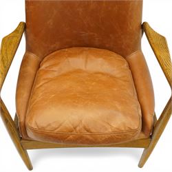 Mid-century design teak open easy armchair with brown leather upholstery, with shaped oak armrests and supports
