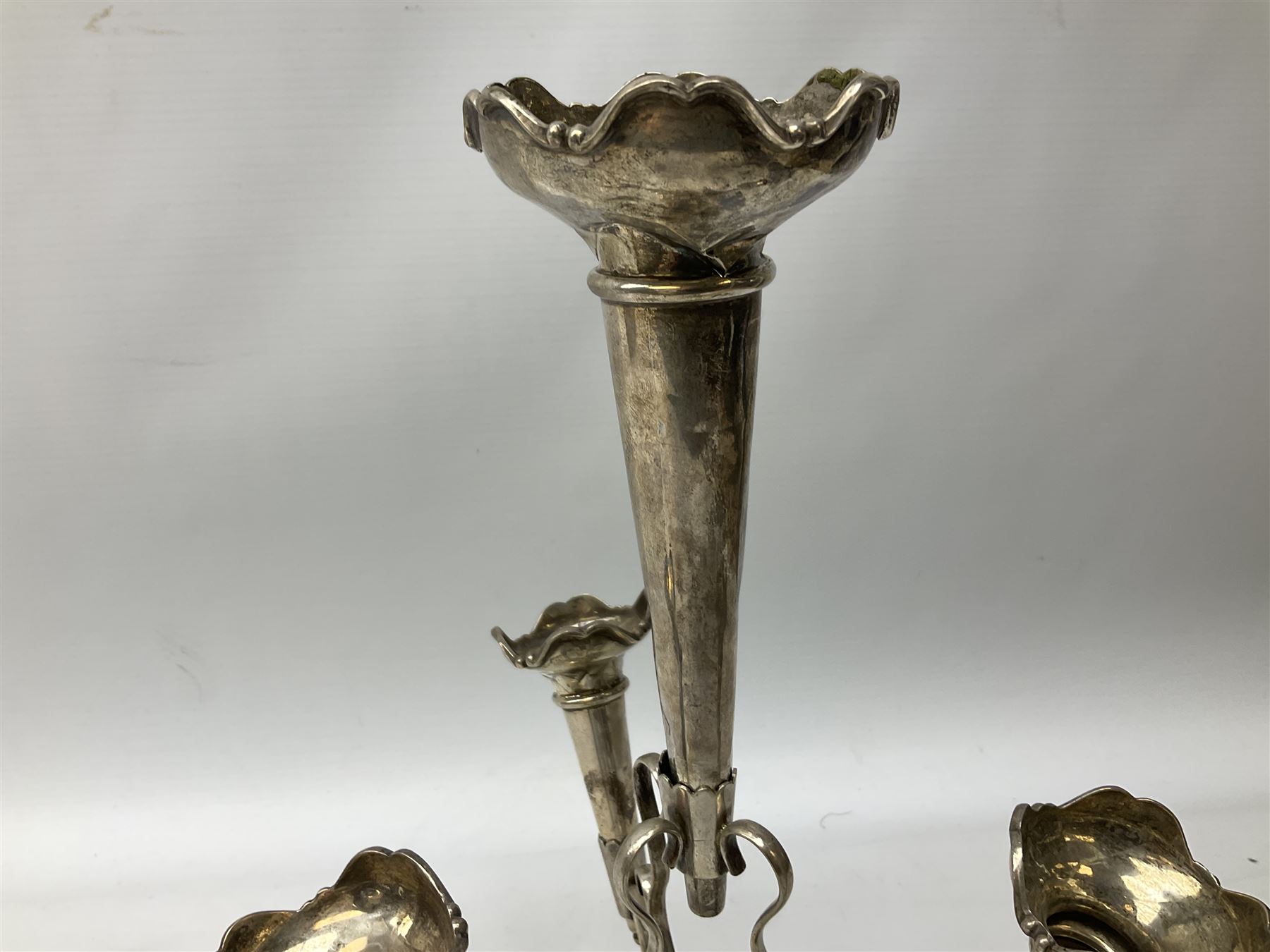 Four hallmarked silver trumpet vases, total weight 108g, upon silver plated stand with foliate decoration and bun feet
