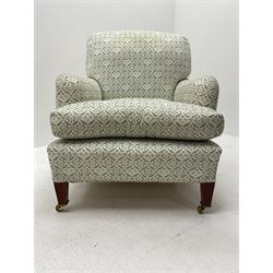 Howard & Sons - Late 20th century armchair, square tapering front supports with brass castors, the rear supports stamped, sprung seats and backs, upholstered in a green and cream foliate patterned fabric

Provenance - Purchased by the vendor from the 