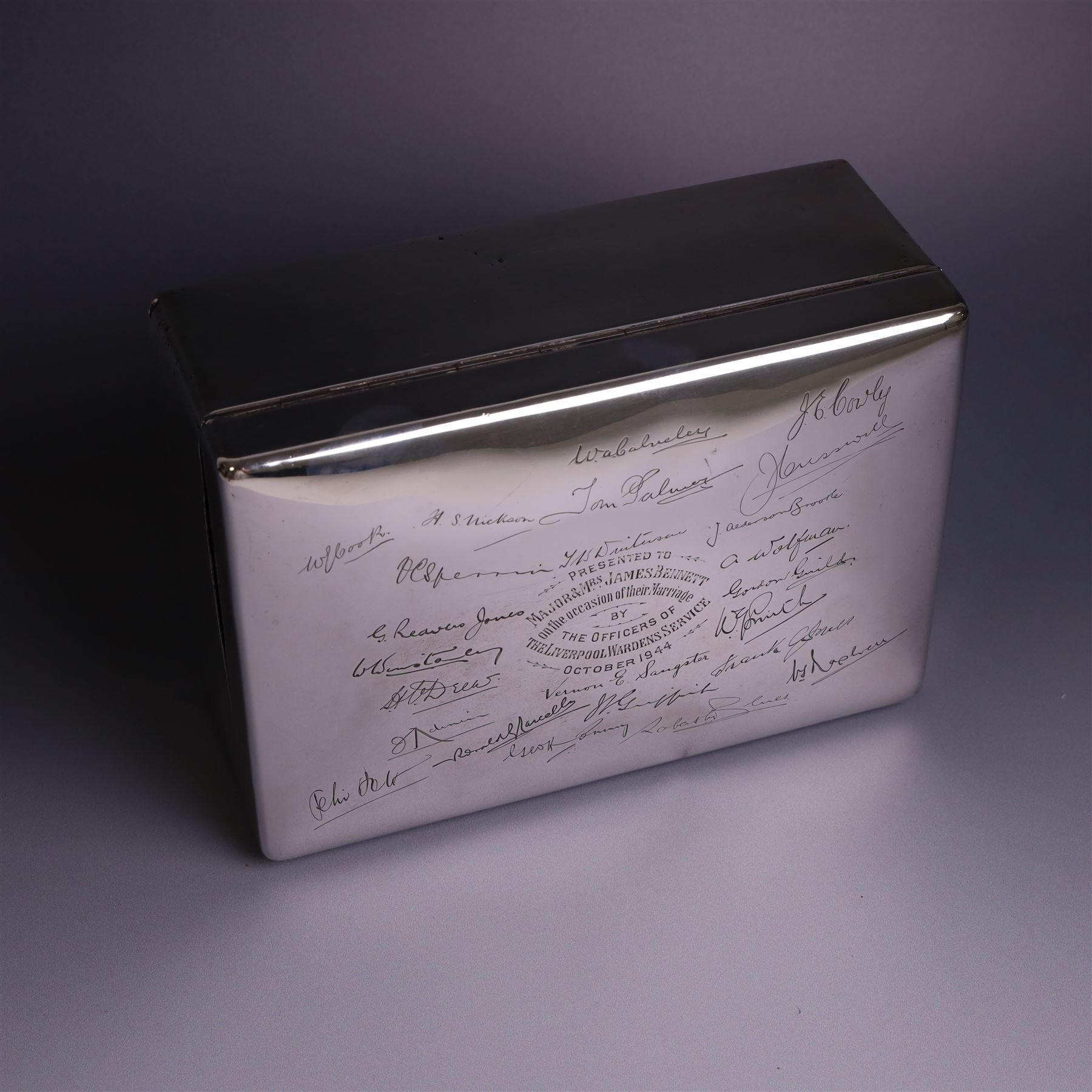 WWII silver mounted cigarette box, of rectangular form, the hinged cover inscribed 'presented to Major & Mrs James Bennett on the occasion of their marriage by the officers of the Liverpool Wardens Service October 1944' and engraved with twenty-four signatures of the officers, with softwood interior, hallmarks worn and indistinct, H7.5cm, W19cm