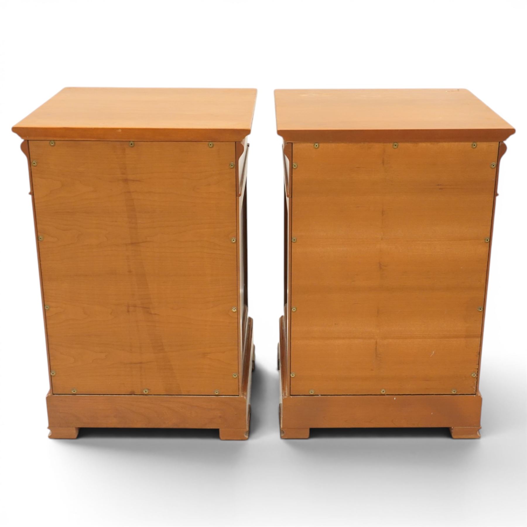 St Michael - pair of cherrywood bedside tables, single drawer above a fielded panel door, brass pulls, raised on a plinth base