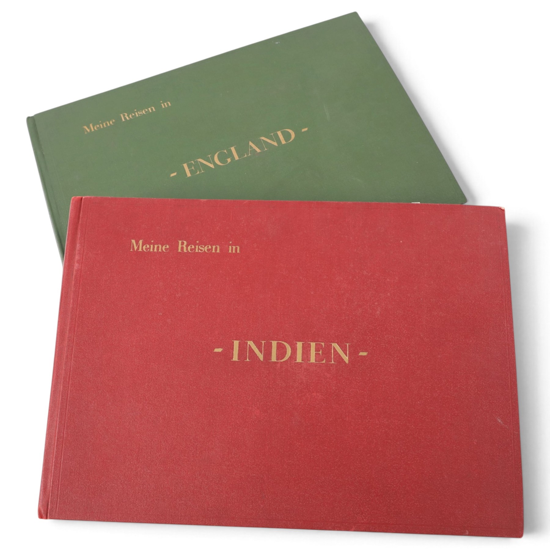 Two early to mid 20th century postcard albums, containing black and white and colour postcards, the first labelled Meine Reisen in Indien containing postcards of Arabia, India, Egypt, some personal photographs and newspaper clippings, of postcards, the second labelled Meine Reisen in England, containing mostly postcards of London, some greetings cards etc
