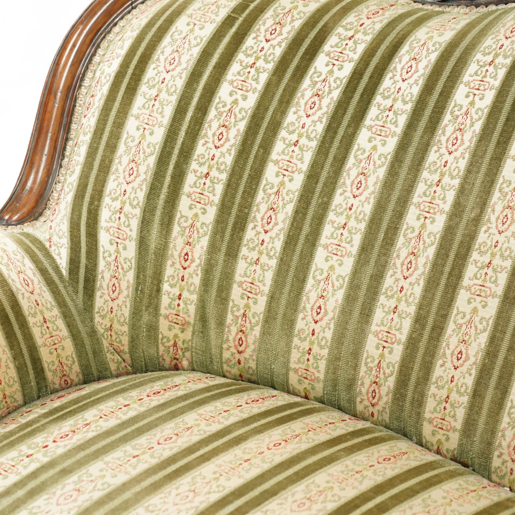 Victorian walnut framed salon sofa, the shaped back and scroll arms with carved floral detail, upholstered in green and cream striped fabric, raised on scrolled cabriole legs 