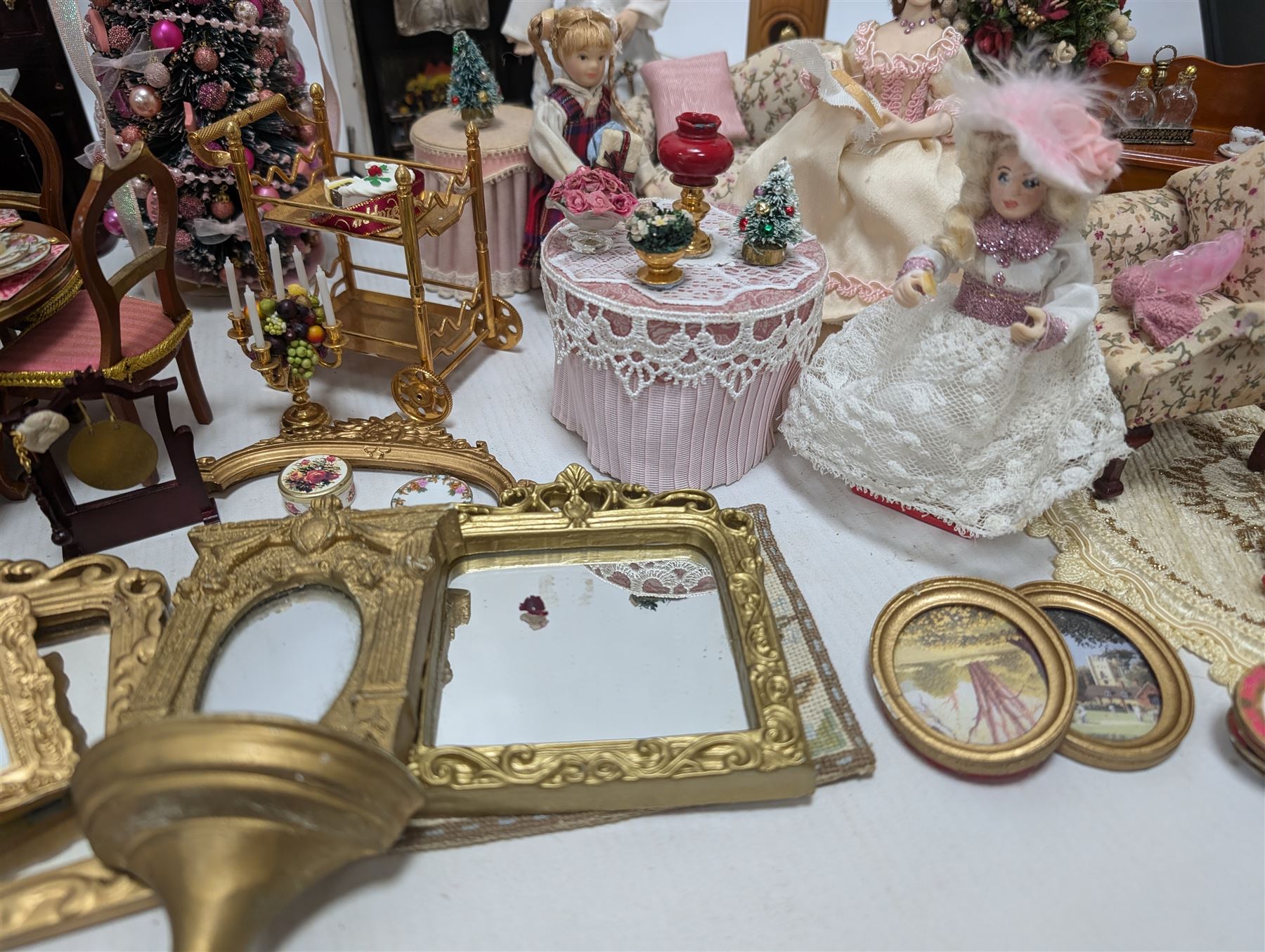 Dolls house living room and ding room furniture, including sofa, chair, long case clock, Christmas trees, fireplace, dresser, chairs, tables, mirrors, seven figures and a collection of predominantly Christmas themed decorations, food, etc