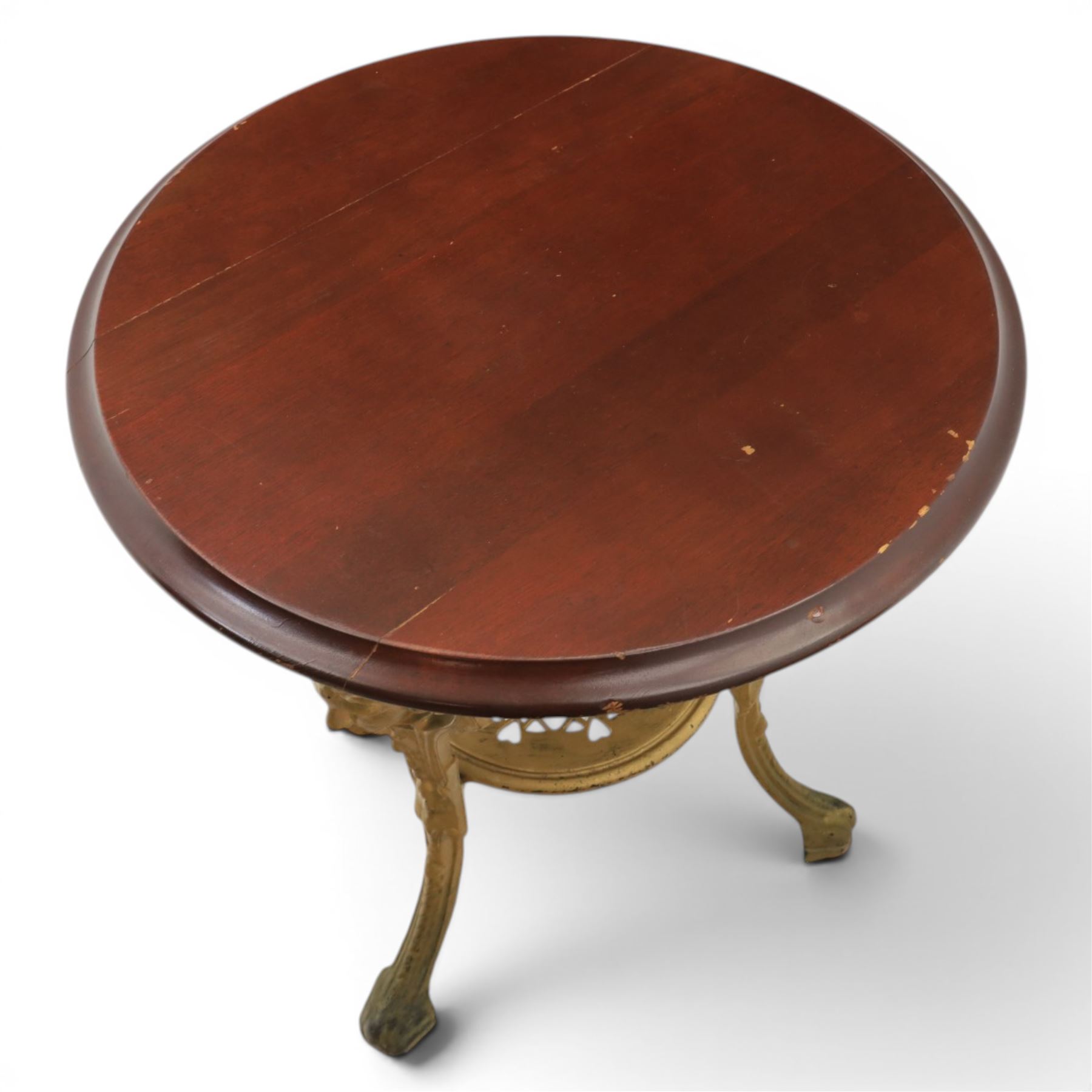 Britannia style cast iron pub table and pair of stools, moulded circular top raised on a gilt painted frame, featuring masks and acanthus detailing united by an under tier, the stools with red floral design (Stools diameter 34cm, height 47cm) 