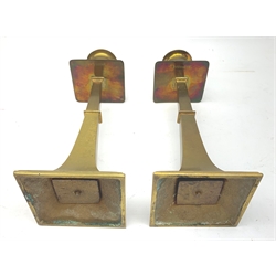 A pair of Aesthetic movement brass candlesticks, the square stepped bases leading to a tapering stem, square drip pan, and circular nozzle, H22cm.