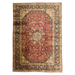 Central Persian Kashan hand-knotted carpet, crimson ground, with a large central ivory and...