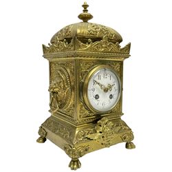 A French twin train striking mantle clock c1890 in a brass case with a decorative plinth raised on four paw feet, pediment with an elongated dome and finial within a raised and crested gallery, matching lion mask carrying handles to the sides, with an enamel dial, upright Arabic numerals , minute track and gilt Louis XV hands within a convex glazed brass bezel, eight day striking movement striking the hours and half hours on a coiled gong. With pendulum.

