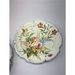 A pair of Italian faience pottery plates, by Giovanni Battista Viero, each of circular form with piecrust rim, with painted floral decoration, each with painted mark beneath, (a/f), D37.5cm