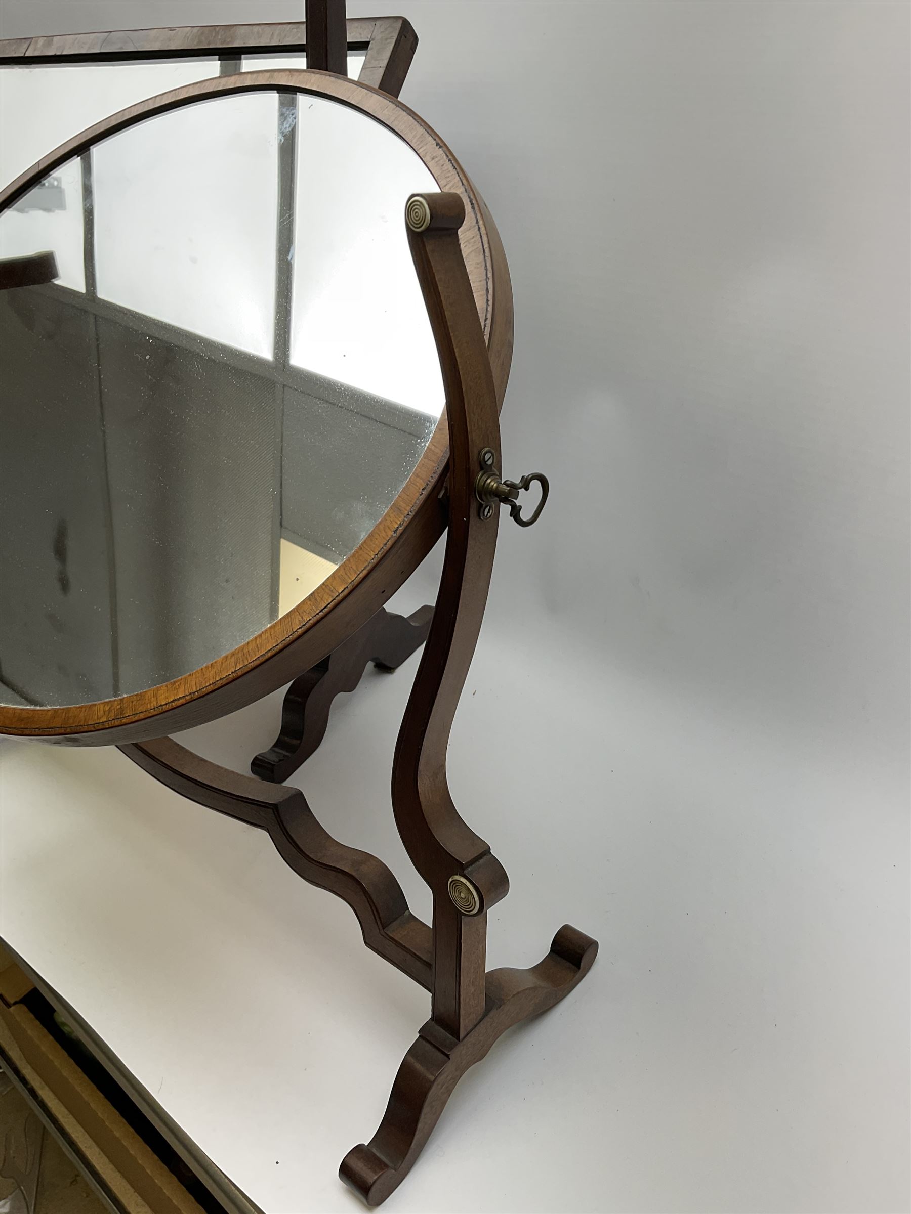An Edwardian mahogany dressing table mirror, the oval mirror plate in swing frame, upon flared legs linked by stretcher, the frame detailed with turned roundels, H49cm, together with a Victorian mahogany example, H50cm. 