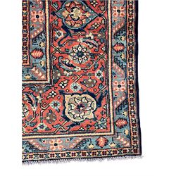 Persian Heratti indigo ground carpet, the busy field decorated with repeating floral pattern Heratti motifs, scrolling leafy branches and palmettes to the crimson ground border, within foliate pattern guard stripes 