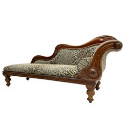 Victorian mahogany framed chaise longue, shaped arm carved with acanthus leaves, the scrolled back with applied carved rosettes,upholstered in monochrome leopard print fabric with bolster cushion, raised on turned supports