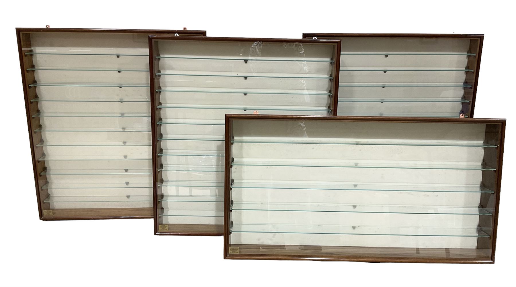 Four die-cast model wall mounting display cases by Picture Pride Displays Sandwell; each with mahogany stained frames and glazed fronts; three 83 x 75.5cm with eleven plate glass shelves and one 57 x 106cm with five plate glass shelves (4)
