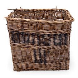 Large 20th century wicker laundry basket, of rectangular form, with stencilled lettering to one sides, raised on wooden base skids