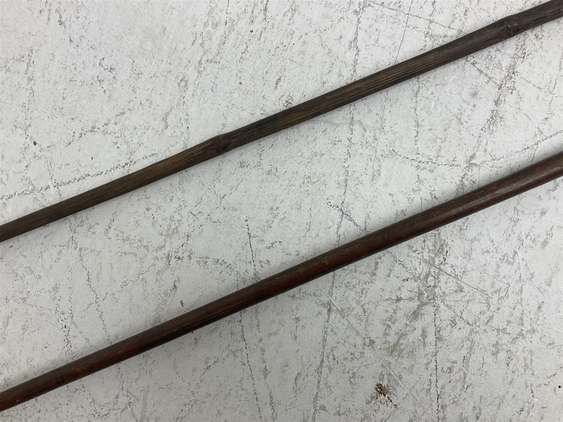 Native long-shafted spear, the large iron head with central medial ridge and decorative neck, on plain circular haft L260cm; and another similar Native long-shafted spear with cane haft L249cm (2)