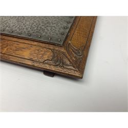 Arts and Crafts oak stand by Arthur Simpson of Kendal, of rectangular form with central hammered pewter panel, surrounded by a border with carved foliate corners, upon two bar supports, bearing label detailed 
