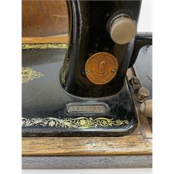A cased vintage Singer hand crank sewing machine. 