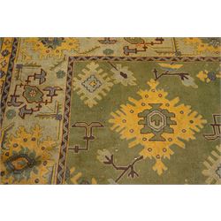 Lage Turkish Oushak green ground carpet, the field decorated with large stylised plant motifs and geometric design, the sage green guard band with further repeating foliate motifs