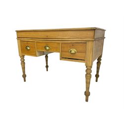 Early 20th century light oak kneehole desk, rectangular hinged top, fitted with frieze drawer flanked by two deep drawers, raised on ring turned supports