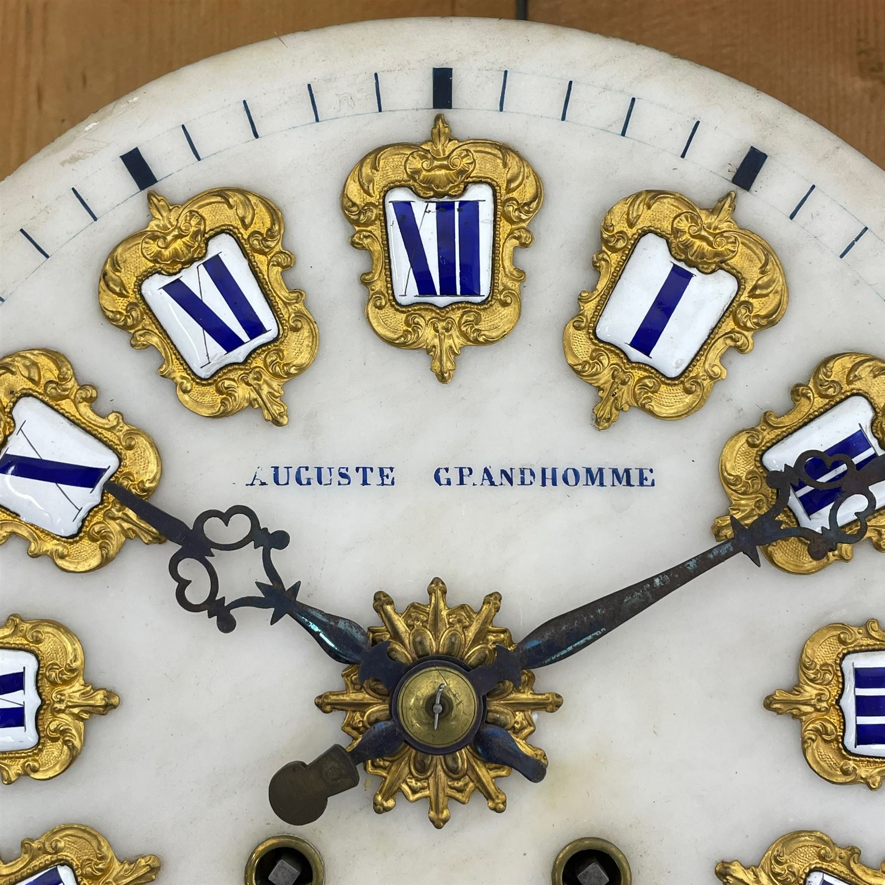 Auguste GP. Andhomme - French vineyard clock,  late 19th century 8-day twin train spring driven wall clock with enamelled and inlaid brass decoration within an ebonised and glazed case, circular enamel dial with cartouche Roman numerals, minute markers, pieced steel hands and a chased brass slip, striking movement, sounding the hours and half hours on a coiled gong. With pendulum and key.  
